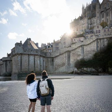 Couple marchant sur le sable devant le Mont-Saint-Michel