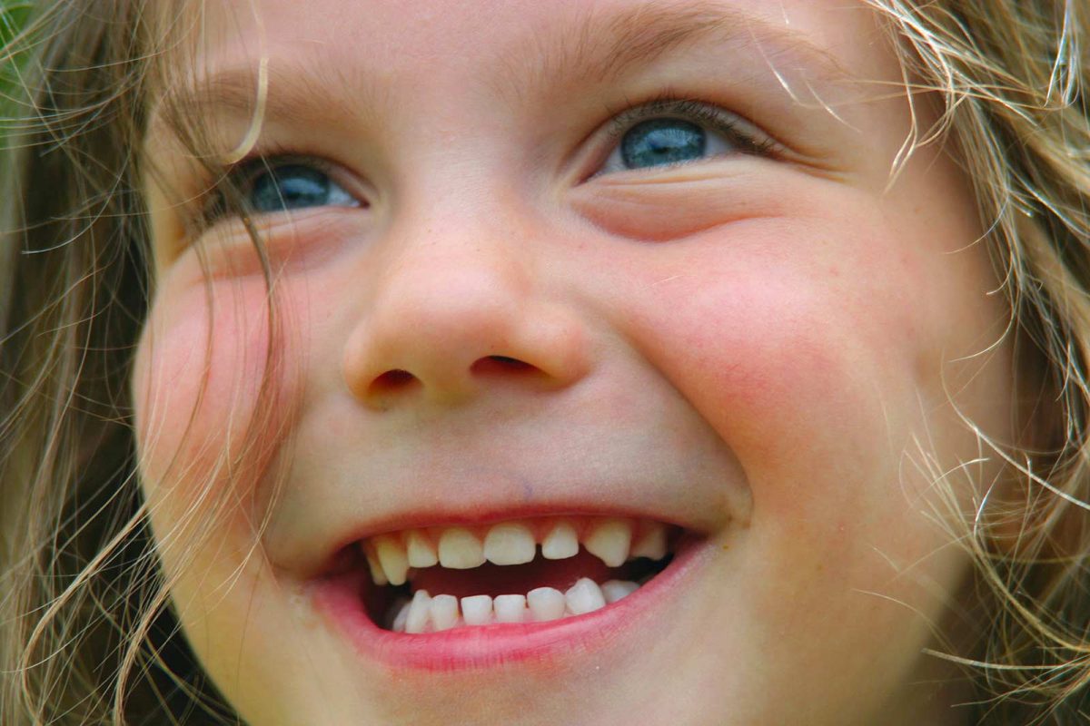 Visage souriant d'une petite fille qui regarde un feu d'artifice