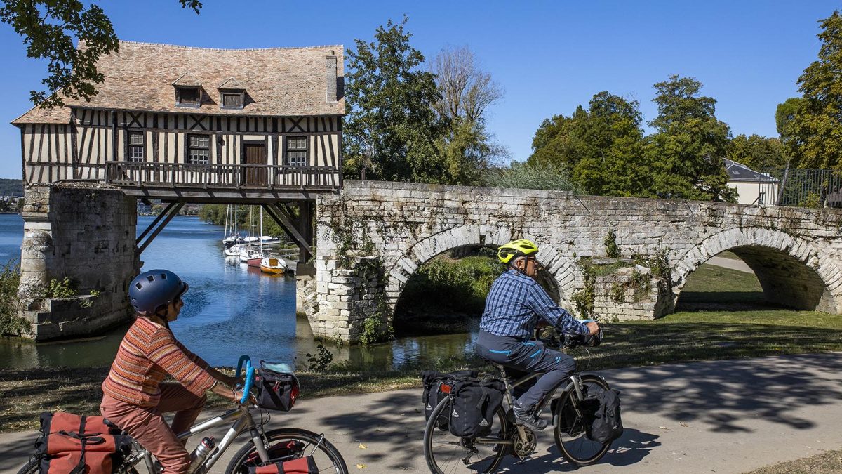couple à vélo devant le vieux moulin de Vernon - La Seine à vélo
